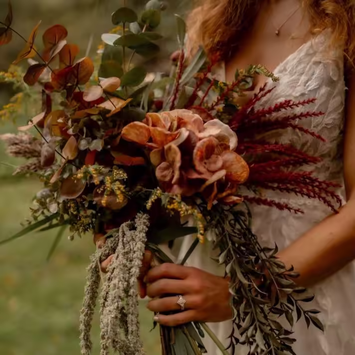 A couple in love, holding hands and walking through a field.