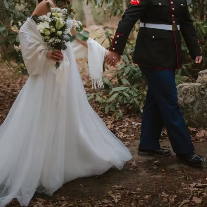 A couple in love, holding hands and walking through a field.